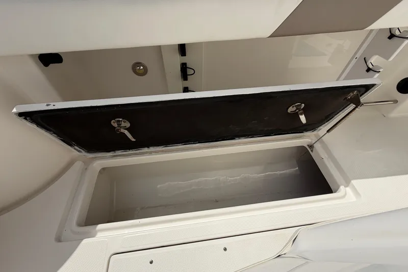 Slide: The Image of Open storage compartment on a 2015 Robalo R300 Center Console boat. - 14