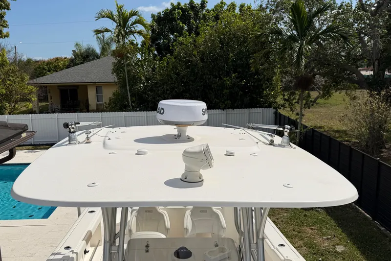 Slide: The Image of 2015 Robalo R300 Center Console boat with radar, viewed from above, near a pool and garden. - 21