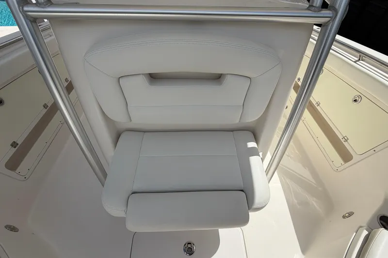 Slide: The Image of 2015 Robalo R300 Center Console boat seat with white upholstery and stainless steel frame. - 22