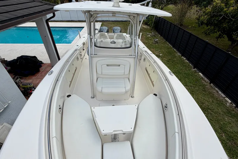 Slide: The Image of 2015 Robalo R300 Center Console boat with spacious seating, docked near a pool. - 9