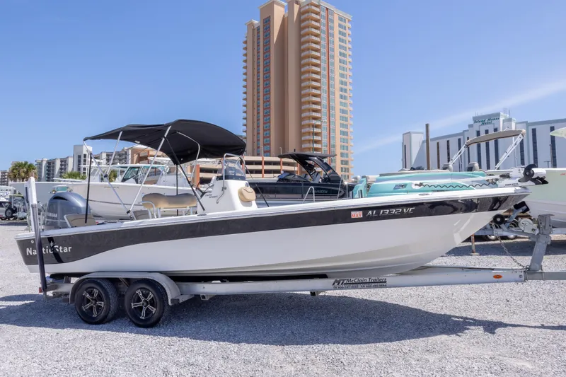The Image of 2017 NauticStar 2400 Sport boat on trailer, cityscape background. - 0