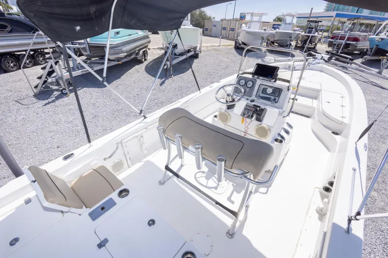 Slide: The Image of 2017 NauticStar 2400 Sport boat interior with console and seating, displayed outdoors. - 16