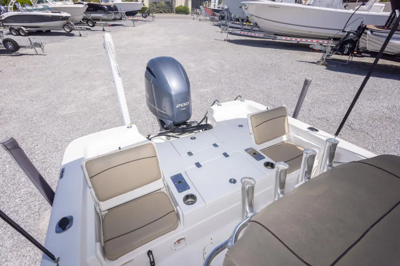 Slide: The Image of 2017 NauticStar 2400 Sport boat with Yamaha 200 engine, parked on gravel lot. - 17