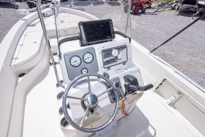 Slide: The Image of 2017 NauticStar 2400 Sport boat dashboard with steering wheel and navigation equipment. - 24