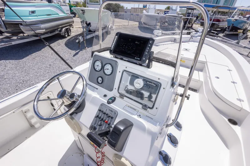 Slide: The Image of 2017 NauticStar 2400 Sport boat dashboard with steering wheel and navigation equipment. - 25
