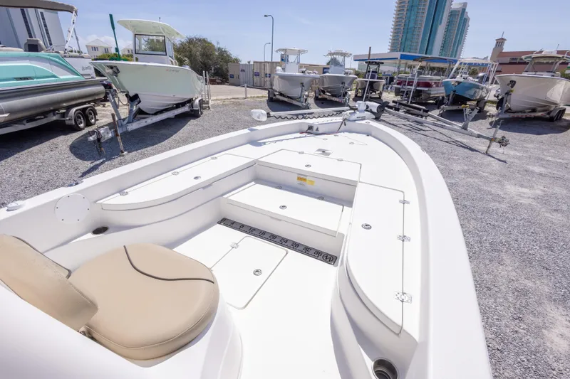 Slide: The Image of 2017 NauticStar 2400 Sport boat on display in a marina with other boats. - 26