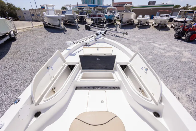 Slide: The Image of 2017 NauticStar 2400 Sport boat with open storage compartments in a boatyard. - 29