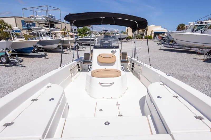 Slide: The Image of 2017 NauticStar 2400 Sport boat with seating, docked in a marina under clear blue skies. - 31
