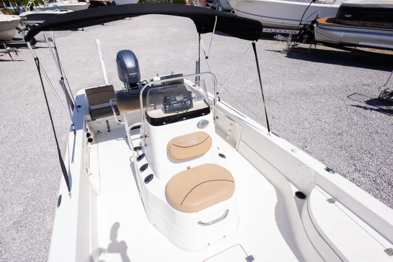 Slide: The Image of 2017 NauticStar 2400 Sport boat with canopy, beige seating, and modern console. - 33