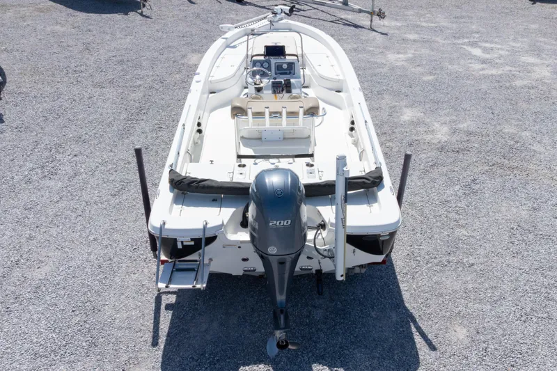 Slide: The Image of 2017 NauticStar 2400 Sport boat, rear view with outboard motor, parked on gravel. - 37