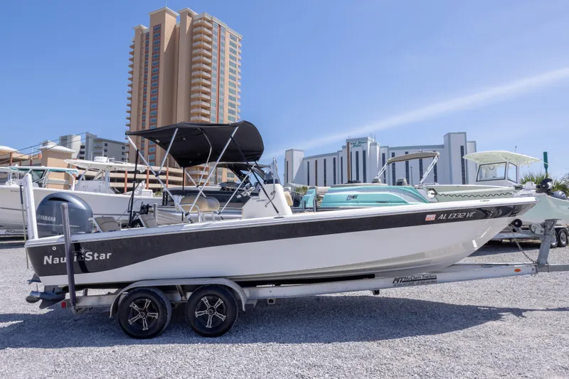 Slide: The Image of 2017 NauticStar 2400 Sport boat on trailer, cityscape background, sunny day. - 5