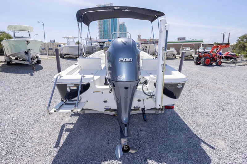 Slide: The Image of 2017 NauticStar 2400 Sport boat with Yamaha 200 engine, parked on gravel lot. - 9
