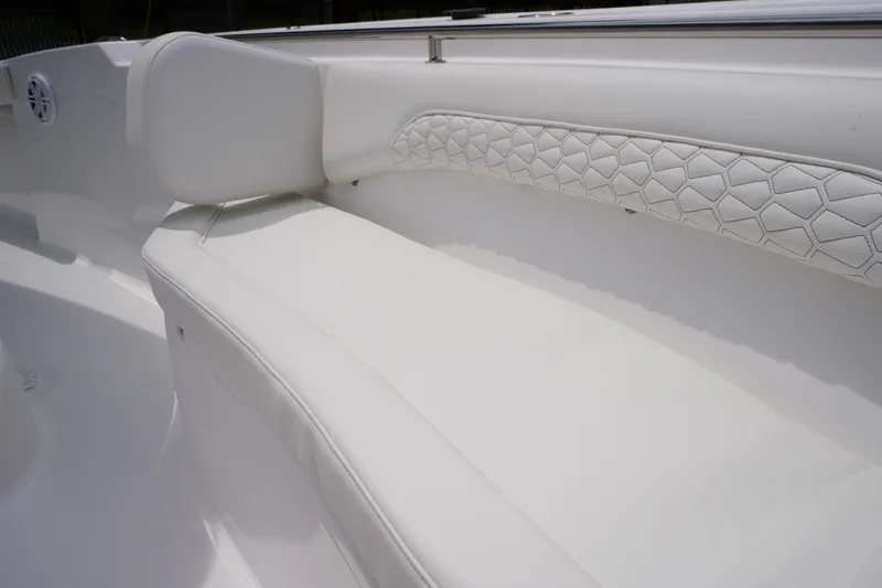 Slide: The Image of 2026 Tidewater 232 SS boat interior with white cushioned seating and hexagonal pattern design. - 12