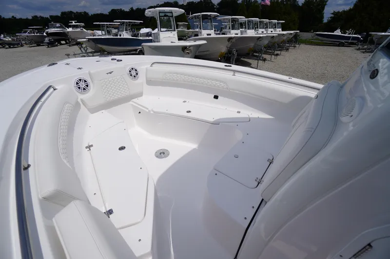 Slide: The Image of 2026 Tidewater 232 SS boat interior with white seating and speakers, docked among other boats. - 17