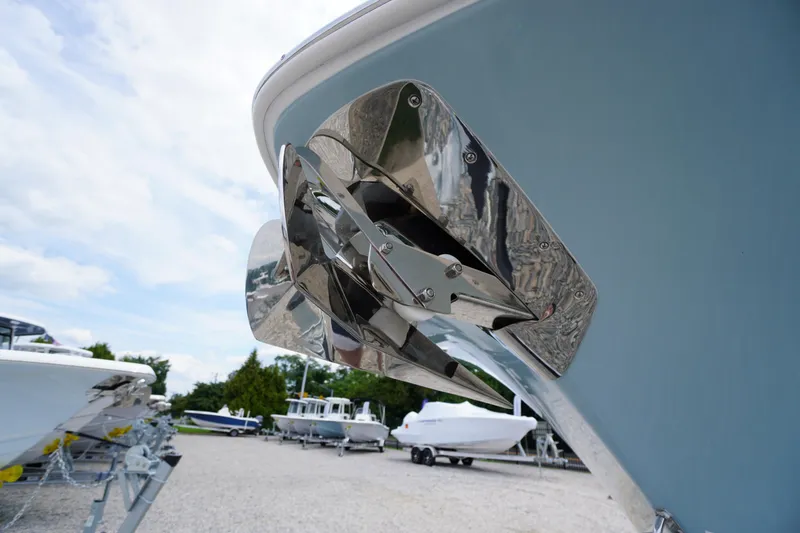 Slide: The Image of 2026 Tidewater 232 SS boat with stainless steel anchor, parked on gravel lot. - 2