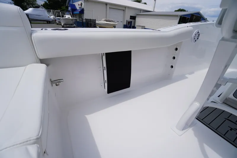 Slide: The Image of 2026 Tidewater 232 SS boat interior with white seating and storage compartment. - 47