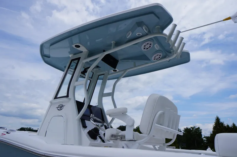 Slide: The Image of 2026 Tidewater 232 SS boat with T-top and seating, under a cloudy sky. - 65