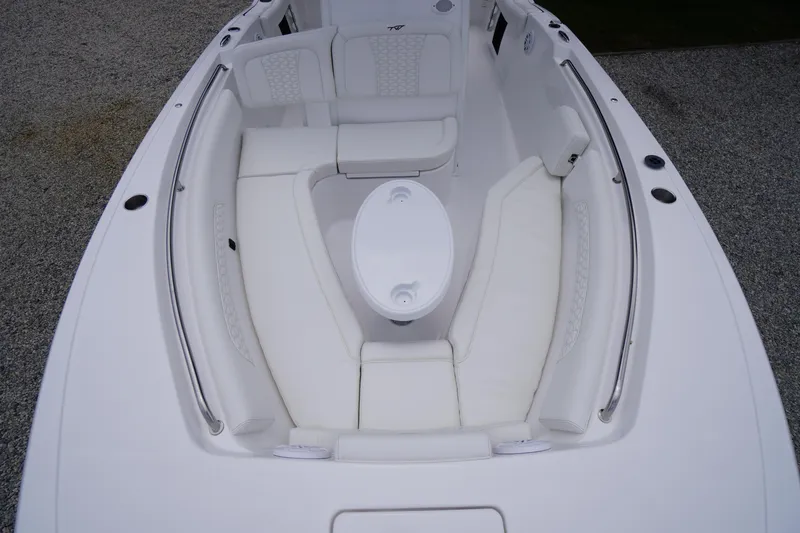 Slide: The Image of 2026 Tidewater 232 SS boat interior with white cushioned seating and oval table. - 7