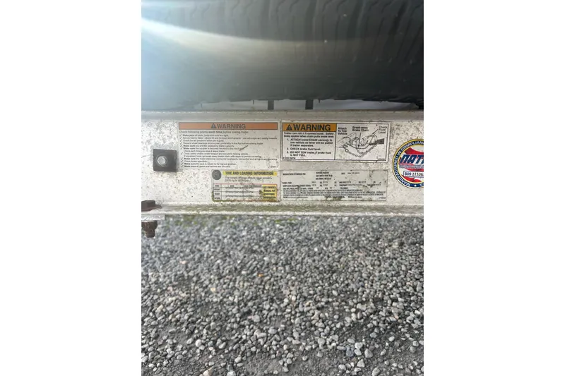 Slide: The Image of Warning labels and tire information on a 2011 Carolina Skiff 258 DLV trailer. - 13