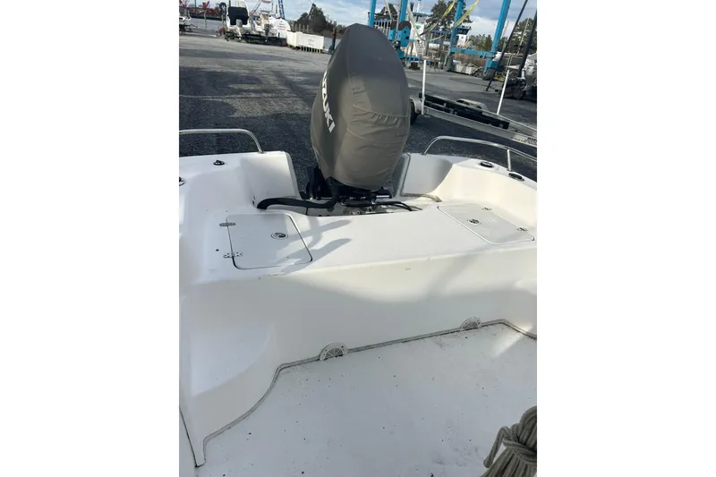 Slide: The Image of 2011 Carolina Skiff 258 DLV boat with covered outboard motor in a marina setting. - 5