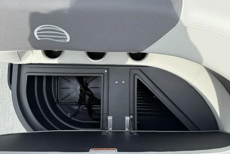 Slide: The Image of 2026 Sun Tracker Bass Buggy 16 XL Select storage compartment with open lid and cup holders. - 24