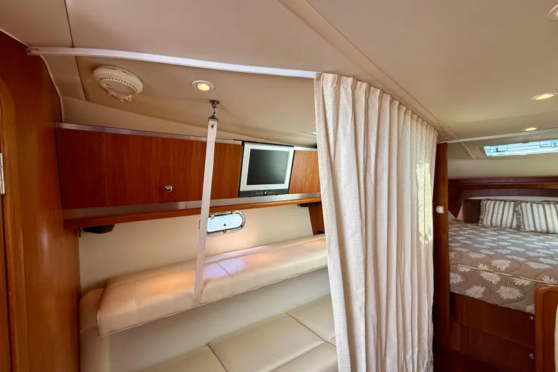 Slide: The Image of 2006 Tiara Yachts 3600 Sovran interior with TV, bunk, and cozy sleeping area. - 10