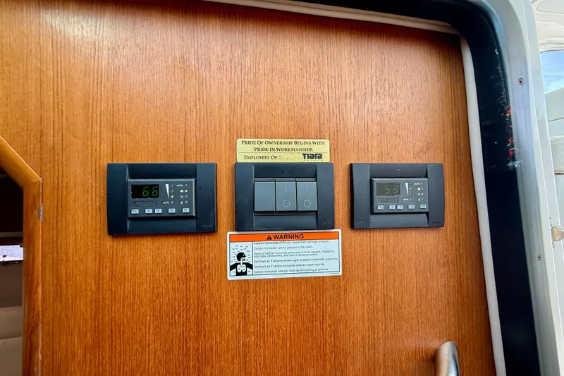 Slide: The Image of Control panel on 2006 Tiara Yachts 3600 Sovran, featuring temperature displays and warning labels. - 14