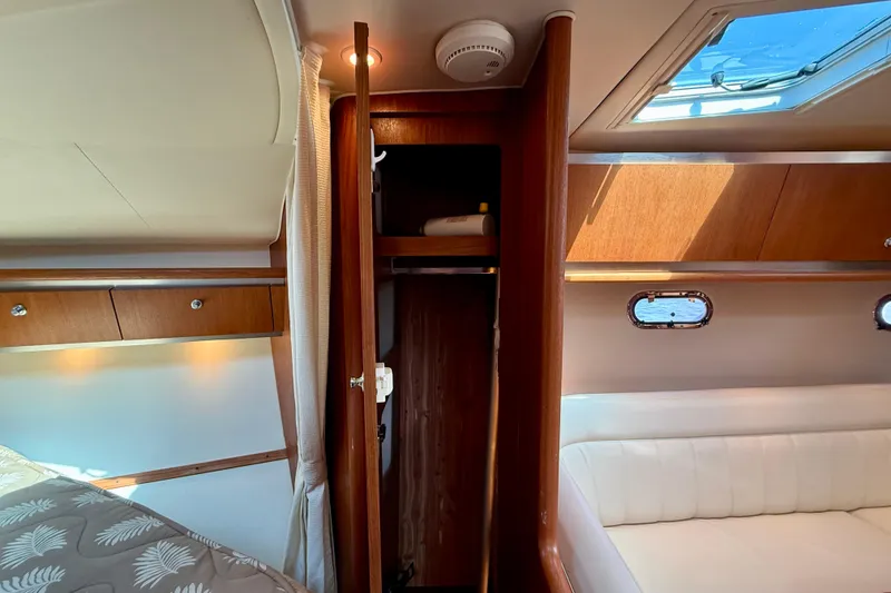 Slide: The Image of Interior of 2006 Tiara Yachts 3600 Sovran, featuring wood cabinetry and a cozy seating area. - 16