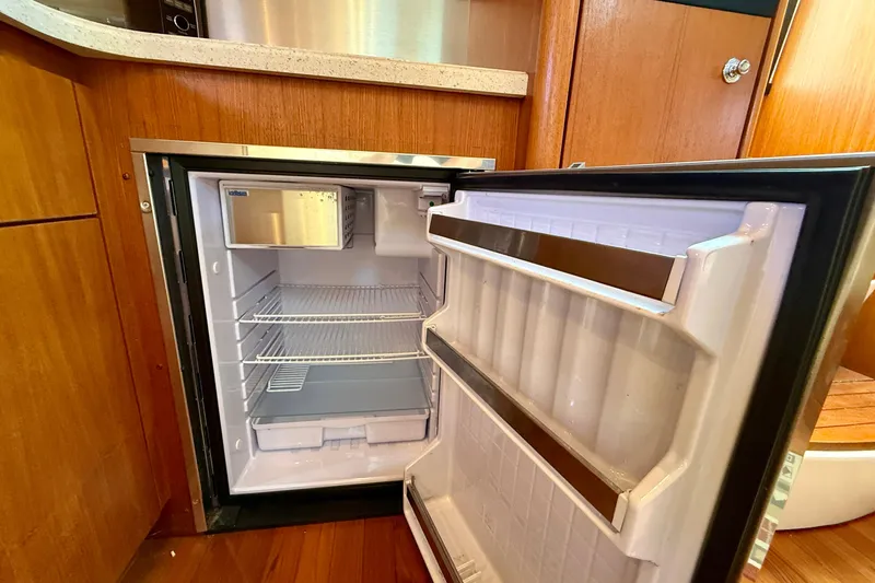 Slide: The Image of Open refrigerator inside 2006 Tiara Yachts 3600 Sovran, showcasing spacious interior and wooden cabinetry. - 21