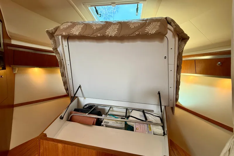 Slide: The Image of 2006 Tiara Yachts 3600 Sovran cabin storage with open hatch and organized compartments. - 23