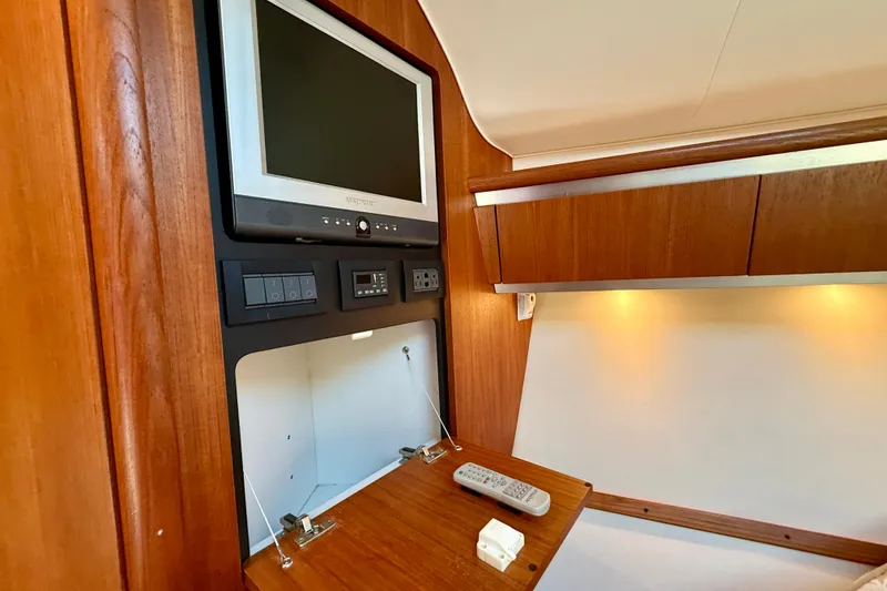 Slide: The Image of 2006 Tiara Yachts 3600 Sovran interior with TV, wooden cabinetry, and ambient lighting. - 25
