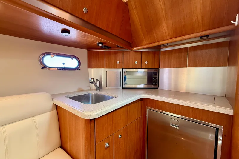 Slide: The Image of 2006 Tiara Yachts 3600 Sovran galley with wood cabinetry, sink, and microwave. - 3