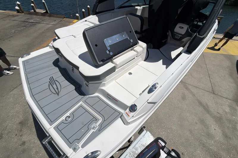 Slide: The Image of 2020 Chaparral 237 SSX boat interior with seating and deck details at a dock. - 25