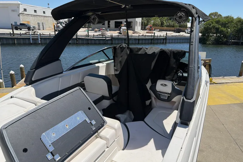 Slide: The Image of 2020 Chaparral 237 SSX boat interior at dockside, featuring seating and canopy. - 26