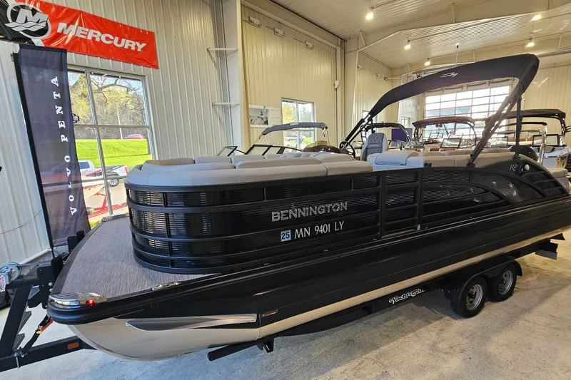 The Image of 2020 Bennington 23 R Swingback pontoon boat displayed indoors with Mercury and Volvo Penta banners. - 1