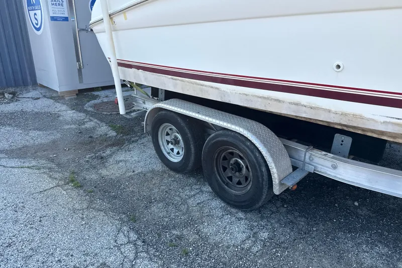 Slide: The Image of Trailer for 1996 Sea Ray 240 Sundancer boat parked on gravel surface. - 10