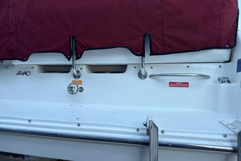 Slide: The Image of 1996 Sea Ray 240 Sundancer boat stern with maroon cover and stainless steel fittings. - 13