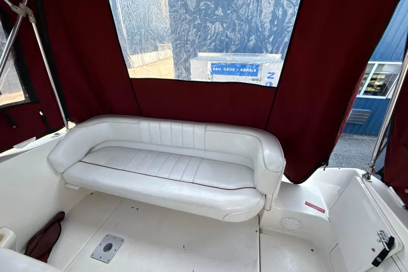 Slide: The Image of Interior of 1996 Sea Ray 240 Sundancer boat with white seating and maroon canopy. - 21