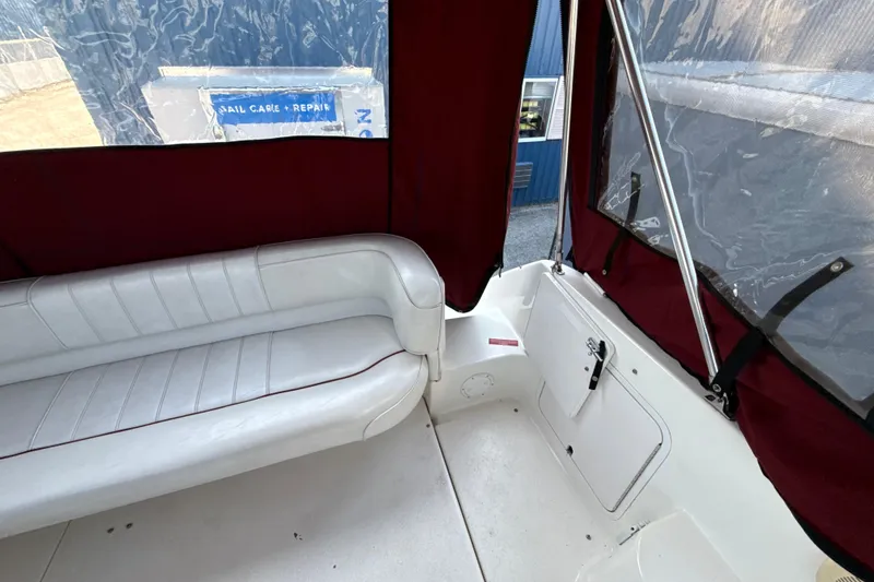 Slide: The Image of Interior of a 1996 Sea Ray 240 Sundancer boat with white seating and maroon canopy. - 22