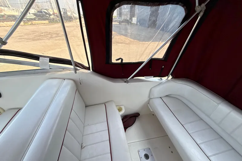 Slide: The Image of Interior of 1996 Sea Ray 240 Sundancer boat with white seating and maroon canopy. - 24