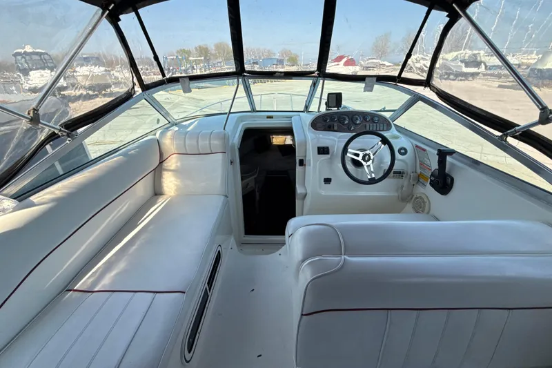 Slide: The Image of 1996 Sea Ray 240 Sundancer boat interior with white seating and steering console. - 25