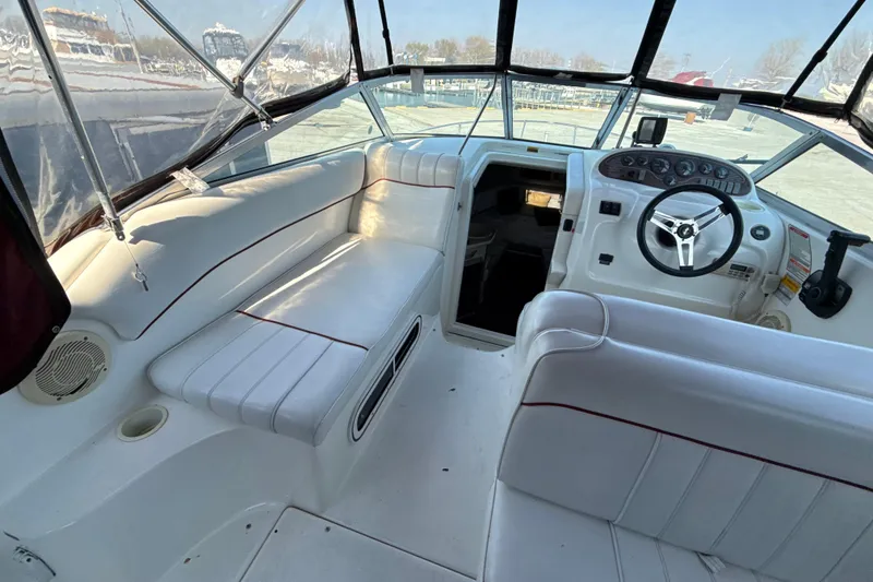 Slide: The Image of 1996 Sea Ray 240 Sundancer boat interior with white seating and steering console. - 26