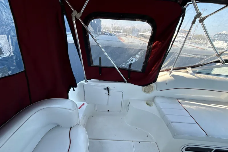Slide: The Image of Interior view of a 1996 Sea Ray 240 Sundancer boat with red canopy and white seating. - 28