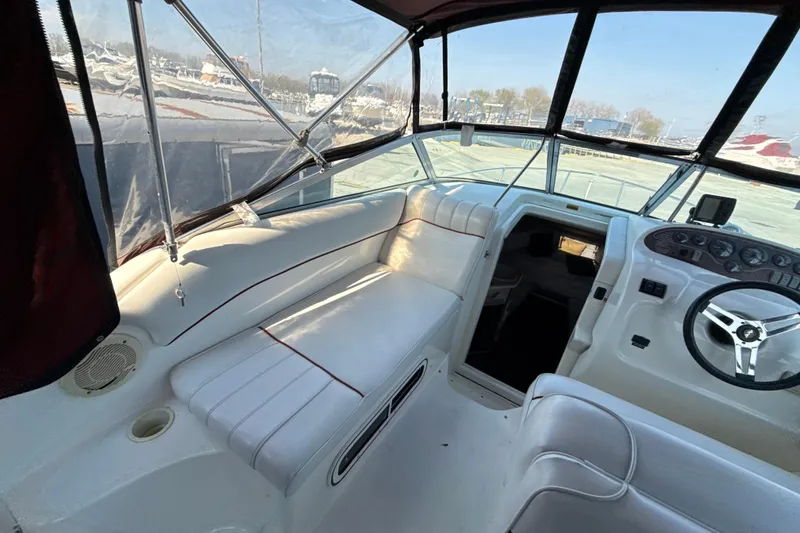 Slide: The Image of Interior view of a 1996 Sea Ray 240 Sundancer boat cockpit with white seating. - 29