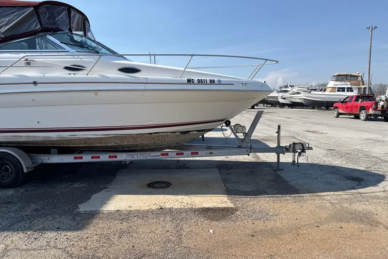 Slide: The Image of 1996 Sea Ray 240 Sundancer boat on trailer in marina parking lot. - 3