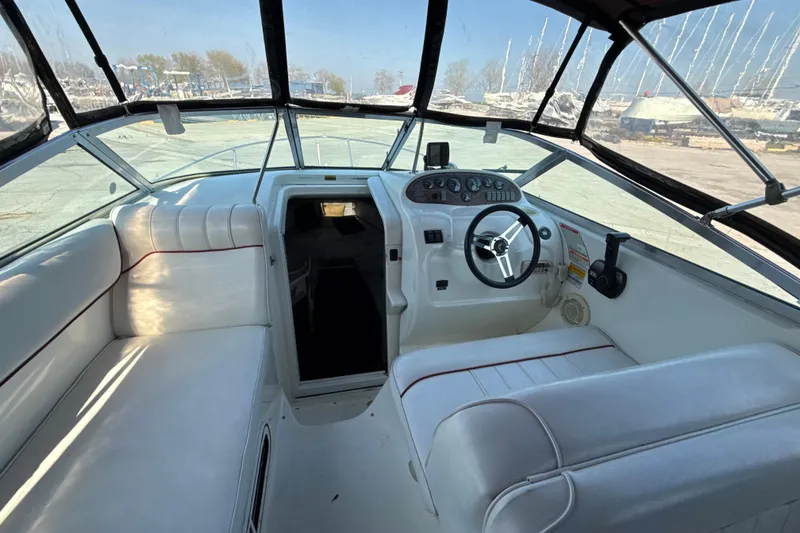 Slide: The Image of 1996 Sea Ray 240 Sundancer boat interior with white seating and steering console. - 30