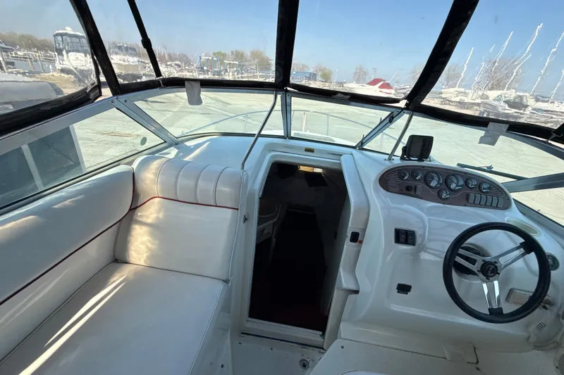 Slide: The Image of 1996 Sea Ray 240 Sundancer boat interior with white seating and control panel. - 31