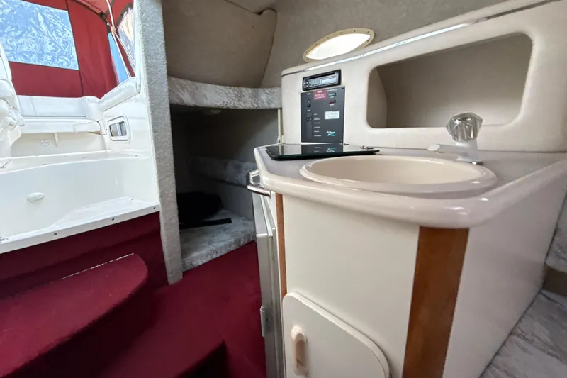 Slide: The Image of Interior of a 1996 Sea Ray 240 Sundancer boat with kitchenette and seating area. - 36