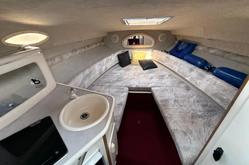 Slide: The Image of Interior cabin of a 1996 Sea Ray 240 Sundancer with cozy seating and a small sink. - 37