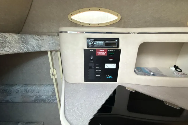 Slide: The Image of 1996 Sea Ray 240 Sundancer cabin interior with control panel and storage. - 49